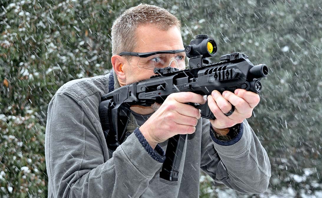 Man in the snow shooting through a Roni Pistol carbine kit